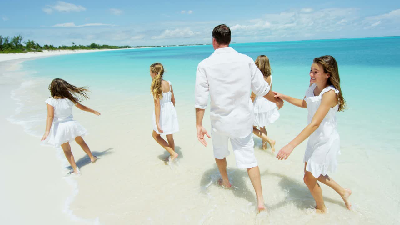 Caucasian family together on beach by tropical ocean
