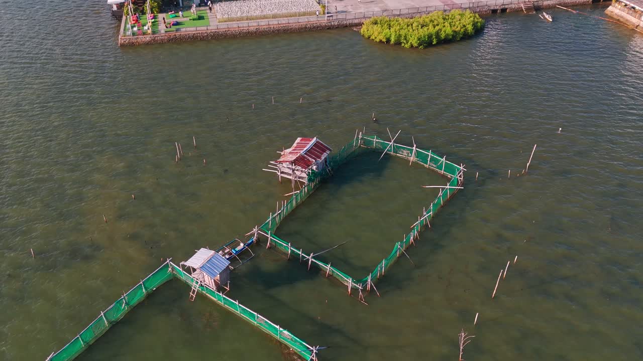 4K aerial drone footage of coastal fish pens and stilt huts over clear tropical water near Cebu, Philippines. Ideal for tourism, aquaculture, sustainability, environment, and traditional fishing