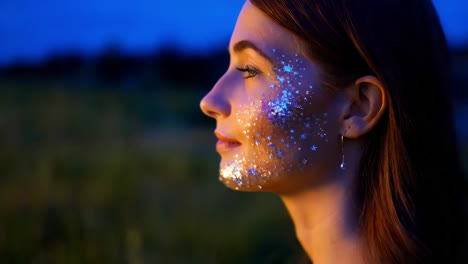 woman with glitter face paint at night