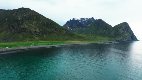 Vista-Aérea-En-órbita-Sobre-Las-Montañas-Y-La-Playa-De-Unstad,-Ubicada-En-Las-Islas-Lofoten,-Noruega