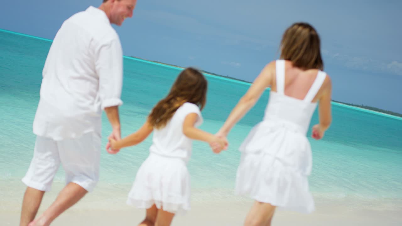 사랑하는 백인 부모와 딸이 해변 휴가를 즐기고 있습니다.