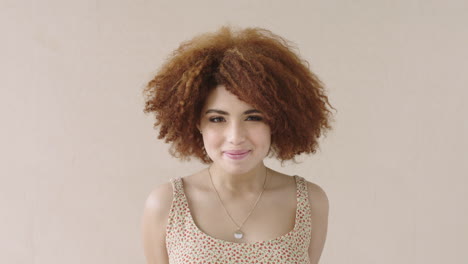 portrait of young shy mixed race woman with afro smiling bashful student