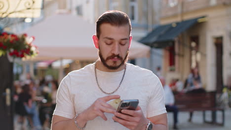 young man using credit bank card smartphone while transferring money purchases online shopping