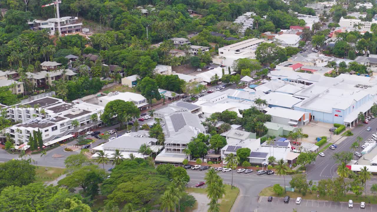 Aerial footage captures lush greenery and urban layout in Port Douglas, Queensland, under soft daylight with smooth camera movement