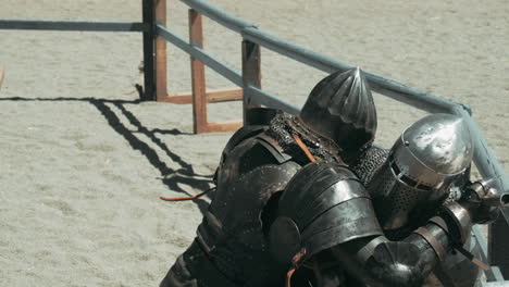 slow motion tracking shot of two knights fighting mutual on sandy field