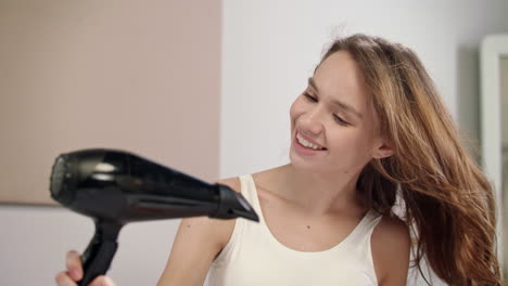 happy woman drying hair in bathroom