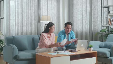 asian couple with a laptop arguing about the bill then being upset due to financial problem