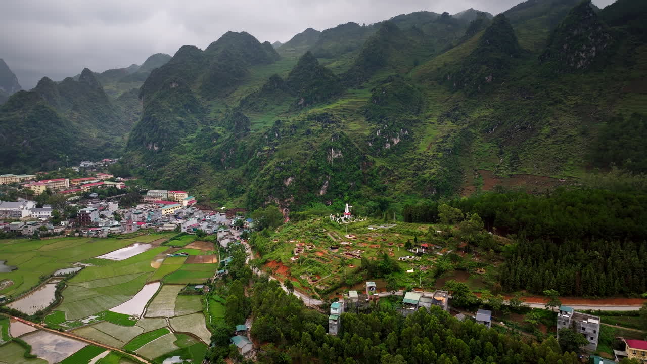 North Vietnamese military cemetery memorial at top of the mountain garden and rice fields in Ha Giang loop, Drone shot
