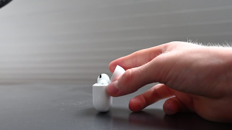 A young music consumer holds in his hands a white compact box designed for earphones