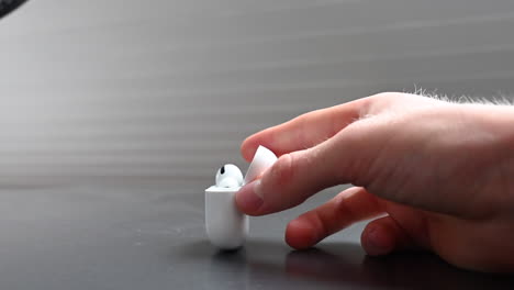 a young music consumer holds in his hands a white compact box designed for earphones