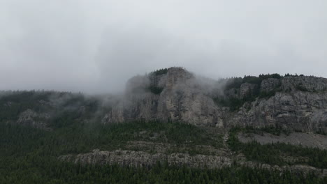 dark misty mountain enshrouded by clouds and trees