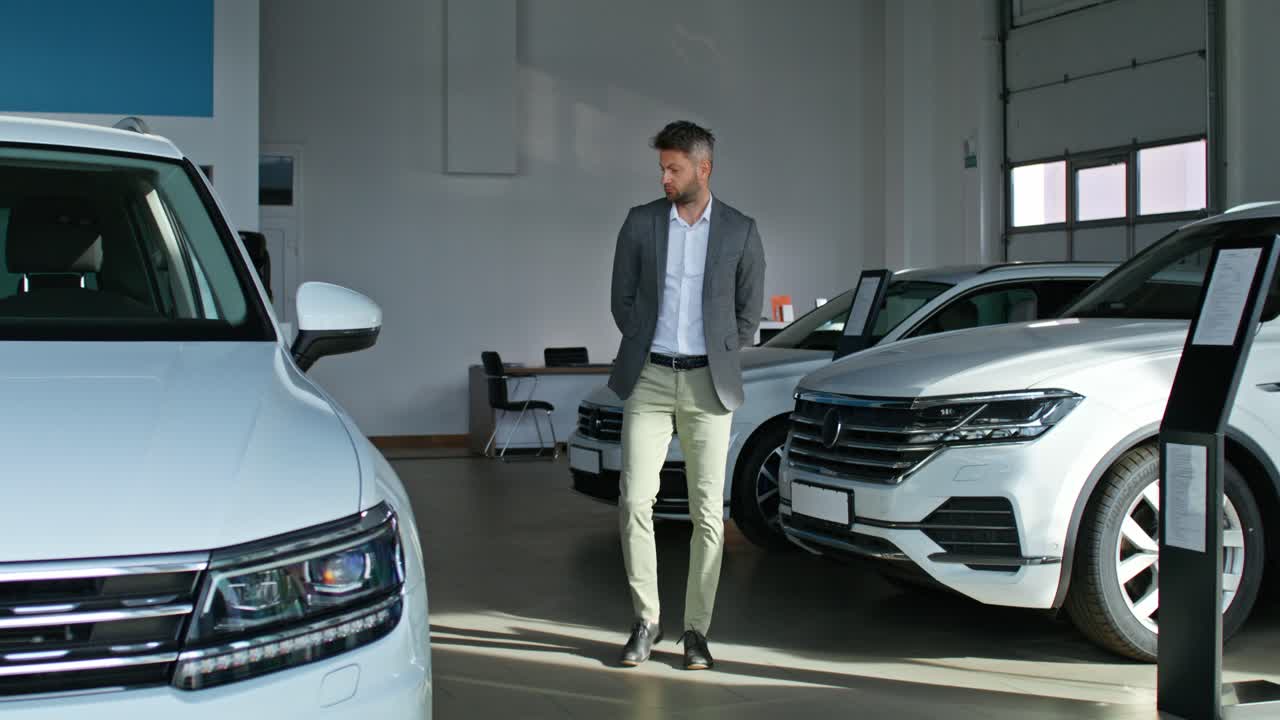 hombre mirando coches en un concesionario