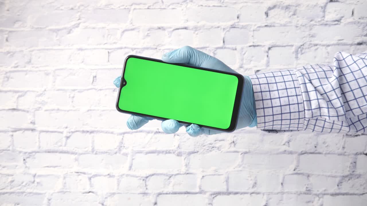 Persona che tiene uno smartphone con schermo verde