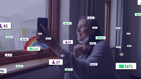 using smartphone with social media notifications, woman standing near window