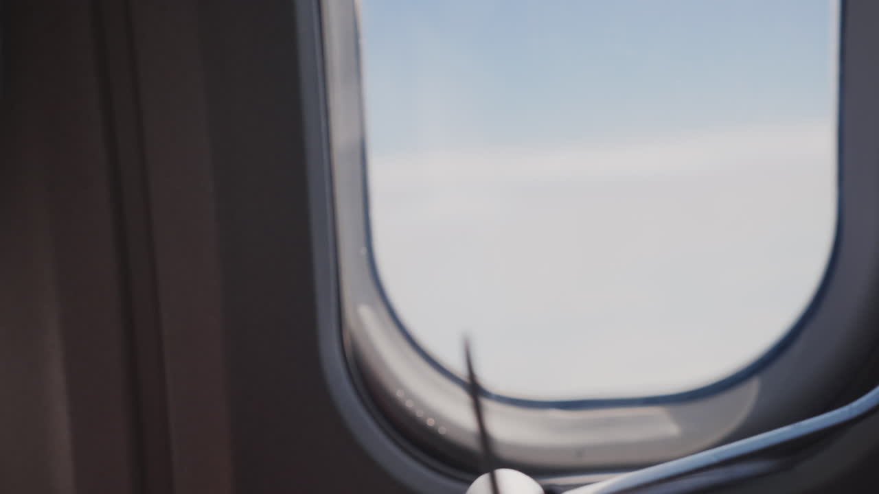 la mano de un niño sostiene un avión de juguete contra el fondo de los sueños y viajes de la ventana del avión