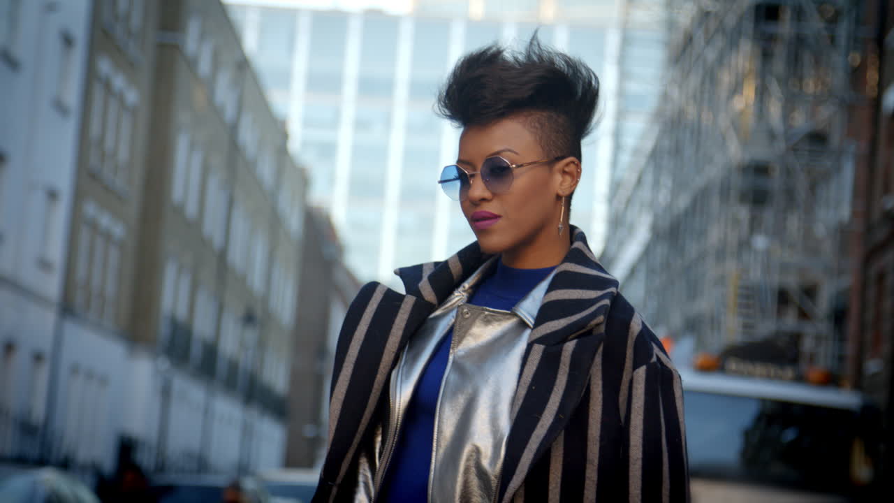 도시 거리에서 서 있는 세련된 패션 블로거