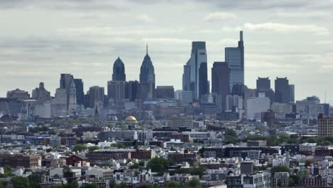 Aerial-view-of-american-neighborhood-with-skyline-and-Skyscrapers-in-downtown-at-sunset