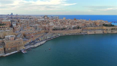 the drone offers a bird’s-eye view of valletta’s grand harbour, where historic ships and modern vessels meet in a scenic backdrop.