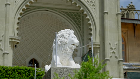 white lion statue in front of a palace