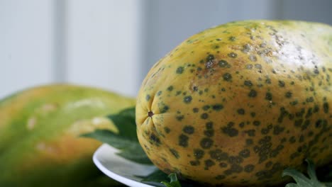 Close-up-of-a-ripe-yellow-papaya-with-spots-on-it-vegan-vegetarian-fruit-paw-paw-vegan