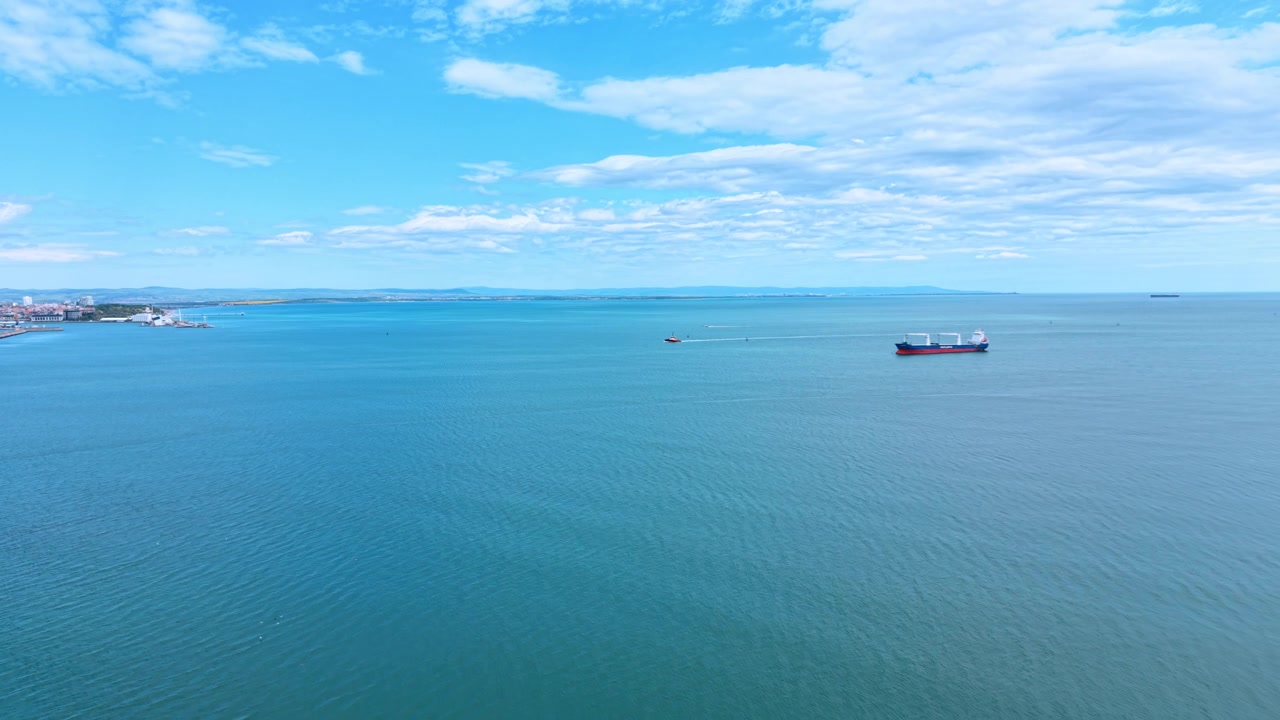 明るい昼間の産業用海港のスカイライン。鮮やかな青い空を背景に、港湾クレーンと輸送インフラが際立つ日中のクリアな眺め。