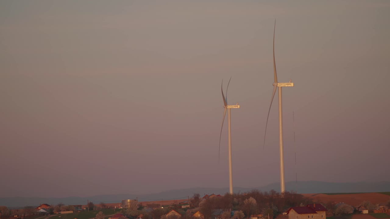 Two Wind Turbines at Sunset