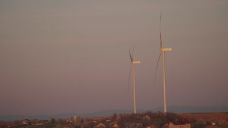 two wind turbines at sunset