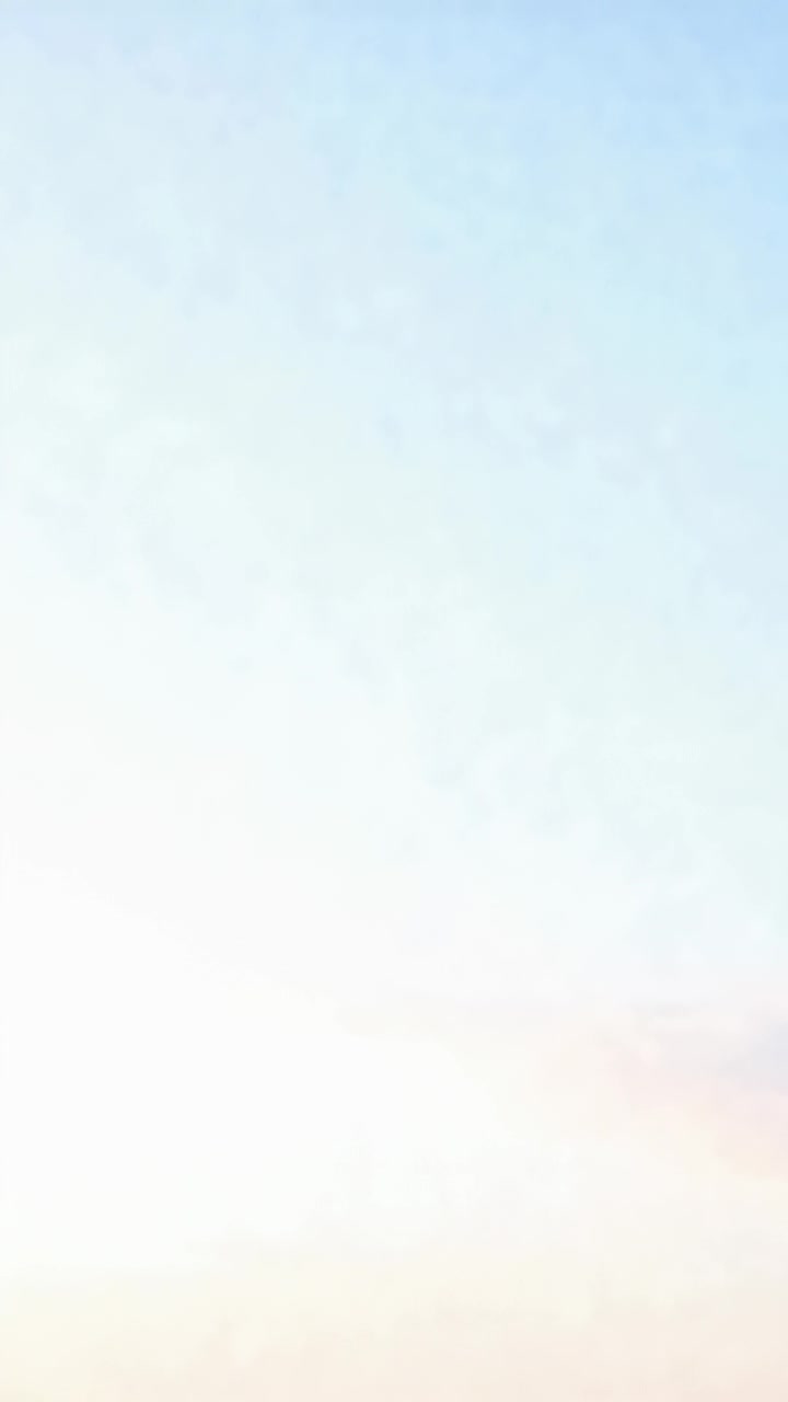 Vertical video: Filming camera capturing pale blue sky at sunrise, showing faint pink haze