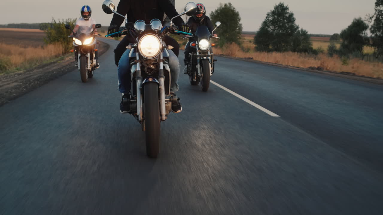 un grupo de ciclistas recorre la carretera por la noche al atardecer