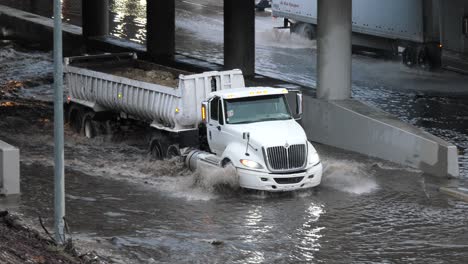 semi truck driving down flooded highway