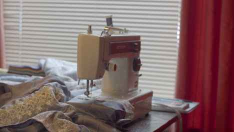 Slow-dolly-in-of-sewing-machine-on-table-with-cloth