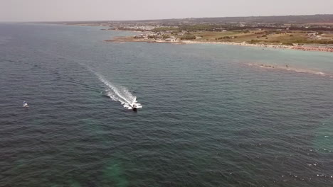 La-Lancha-Navega-A-Lo-Largo-De-La-Costa-De-La-Playa-De-Specchiolla-En-Puglia,-Italia