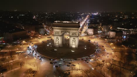 Coches-Circulando-Alrededor-Del-Arco-Triunfal,-París-De-Noche,-Francia