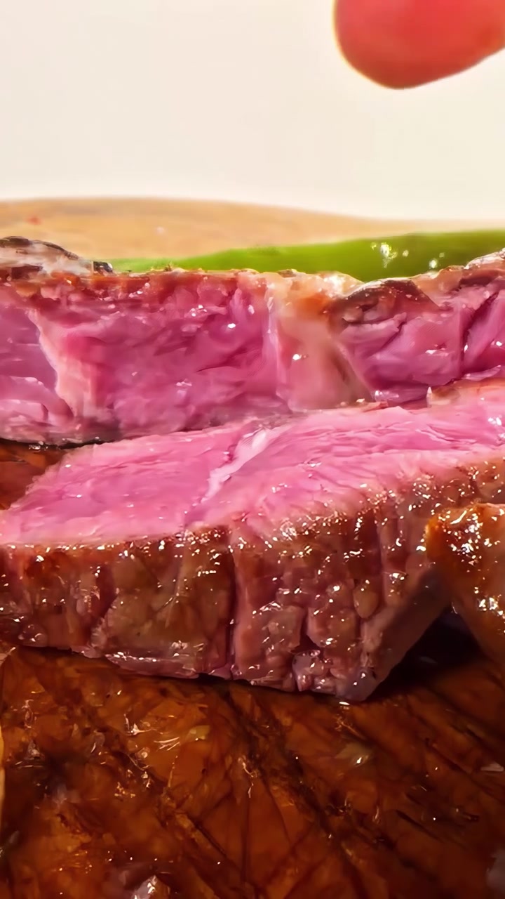 Uno chef affetta una bistecca al sangue, rivelandone l'interno succoso e la crosta rosolata. Ideale per blog culinari o tutorial di cucina.
