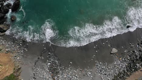 Vista-De-Arriba-Hacia-Abajo-De-Las-Olas-Salpicando-En-La-Costa-Rocosa---Toma-Aérea-De-Drones