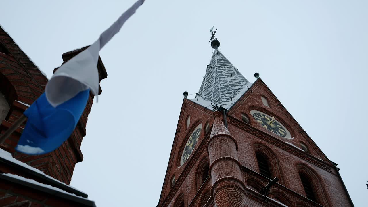Majesteettinen goottilainen tiilikirkko lumen peitossa ankaran talven aikana.