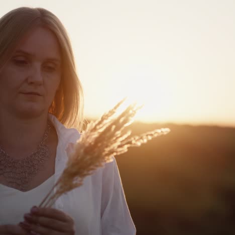 Mujer-Se-Encuentra-Al-Atardecer-En-Un-Campo-De-Hierba-2