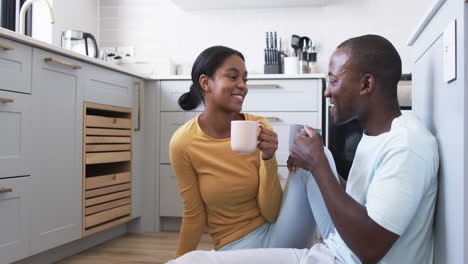 Una-Joven-Pareja-Afroamericana-Disfruta-De-Un-Momento-En-Su-Cocina,-Tomando-Café