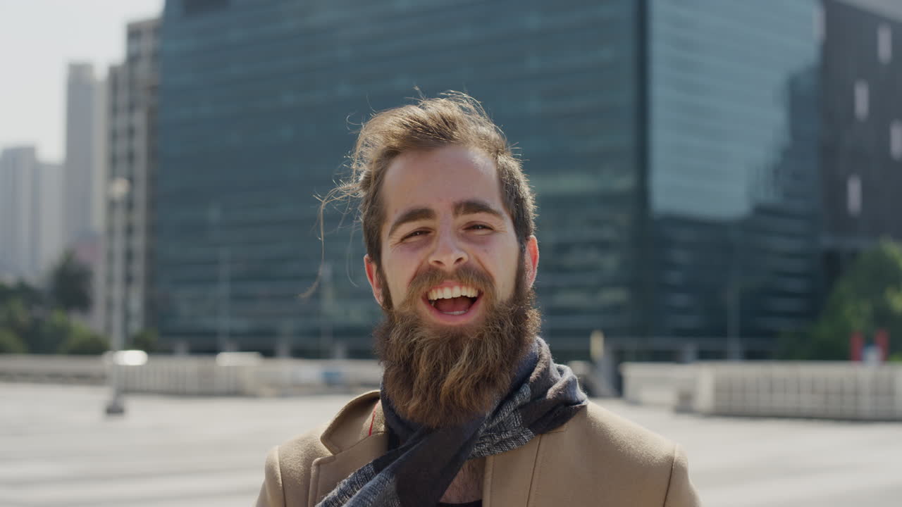retrato profesional joven hombre hipster riendo disfrutando de un estilo de vida urbano exitoso feliz empresario barbudo en la ciudad soleada al aire libre cámara lenta