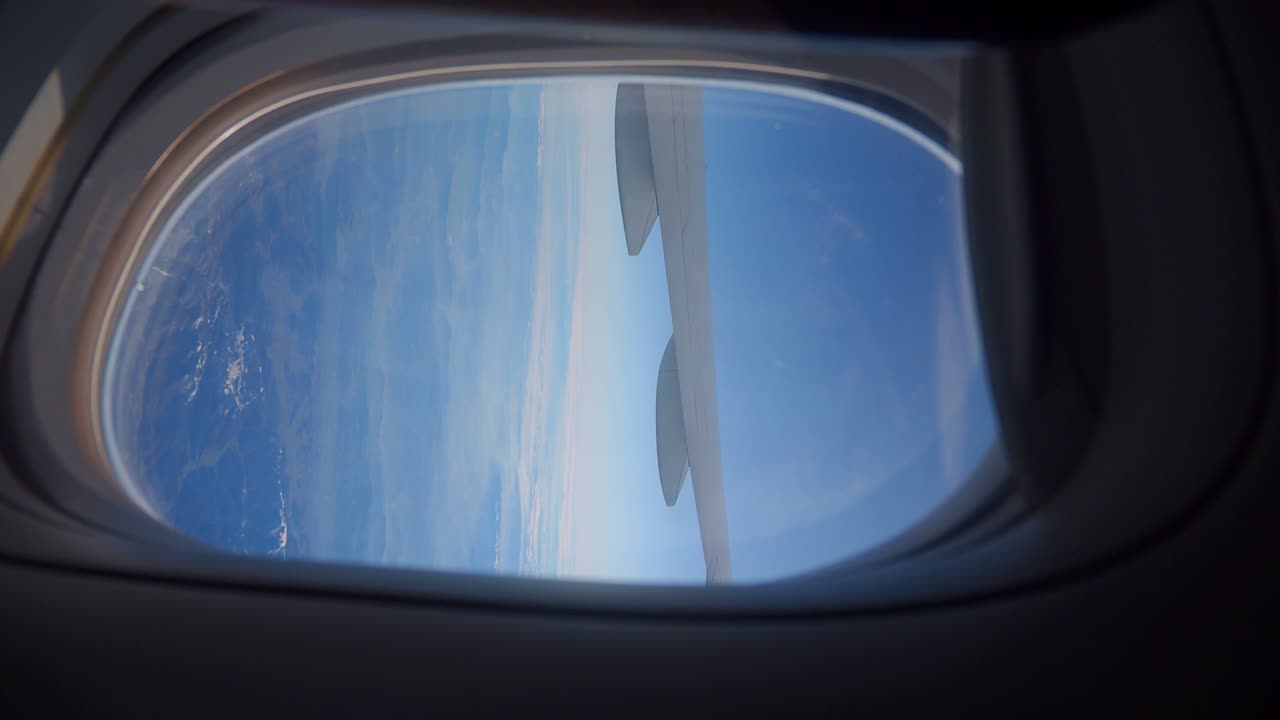 Airplane Window View of Clouds and Wings
