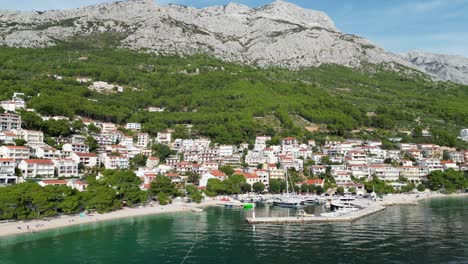 Brela-Croatia-Ciudad-Y-Puerto-Frente-Al-Mar-Drone-Push-In-Shot