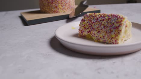 close up shot of slice cut from rainbow celebration cake on plate 2