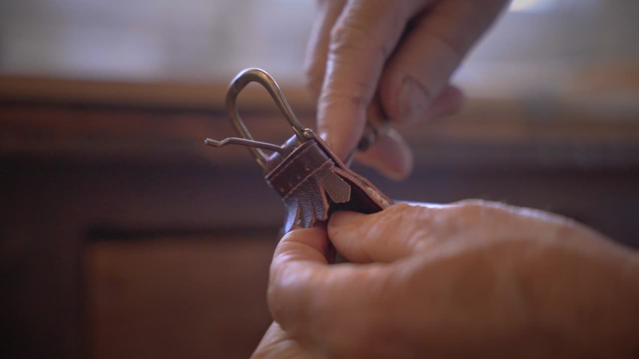 peletero reparando un cinturón de cuero primer plano