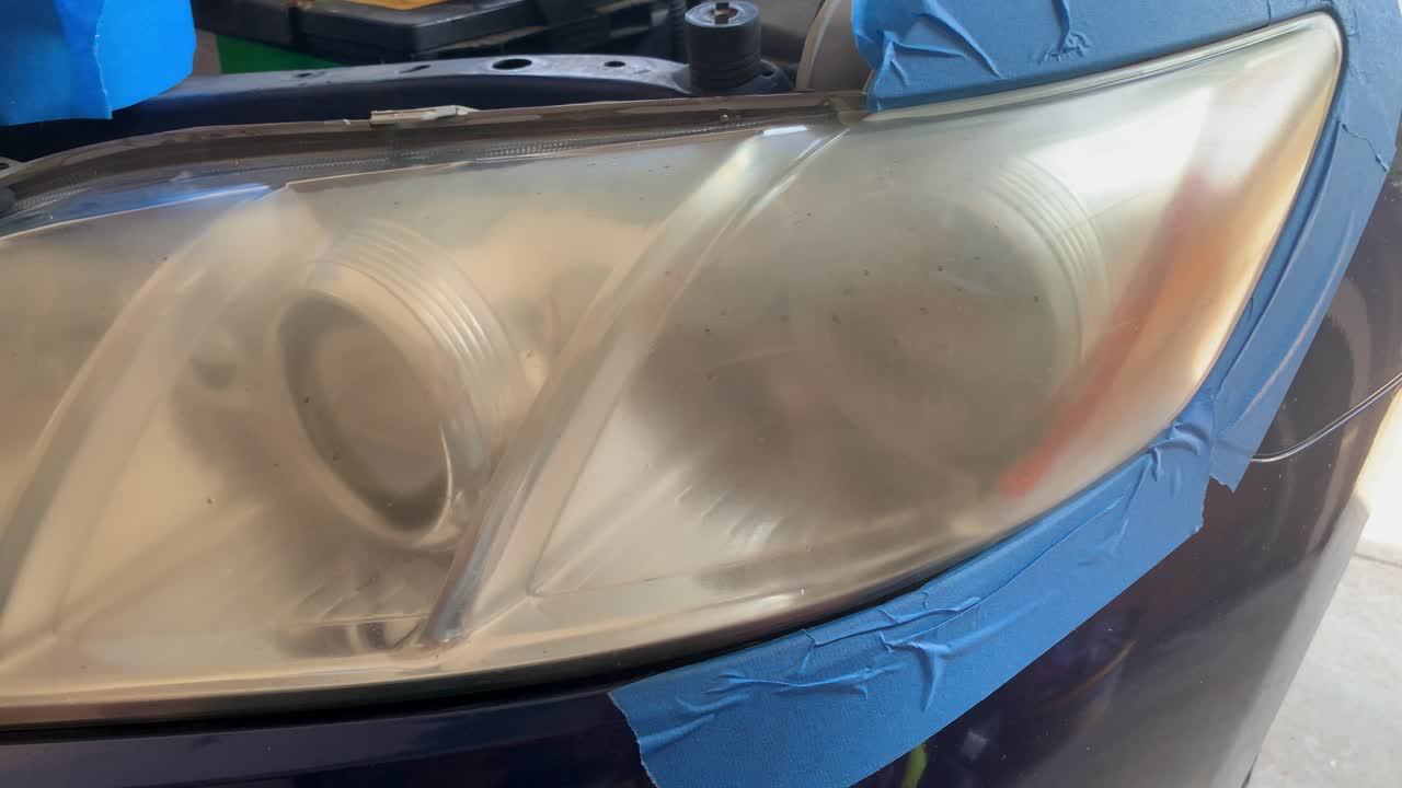 Car headlight being prepared to be treated for oxidation