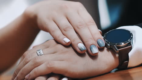 mujer con una manicura elegante golpea la mano del hombre amado