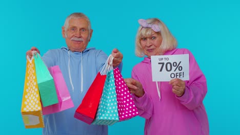 abuelos mayores con bolsas de compras y hasta un 70 por ciento de descuento en el texto de la pancarta, vacaciones de viernes negro