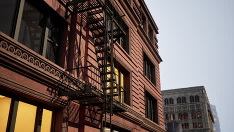 old brick building with fire escape at sunset