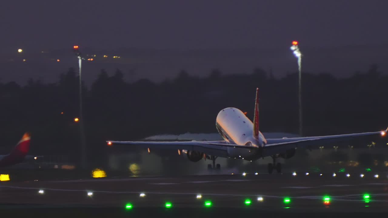 Atterraggio e rullaggio di un aereo su pista, dal crepuscolo alla notte