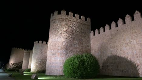 the old town of avila after dark, with its unesco-protected medieval walls shining brightly.