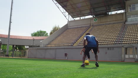 father and son practicing soccer in a stadium